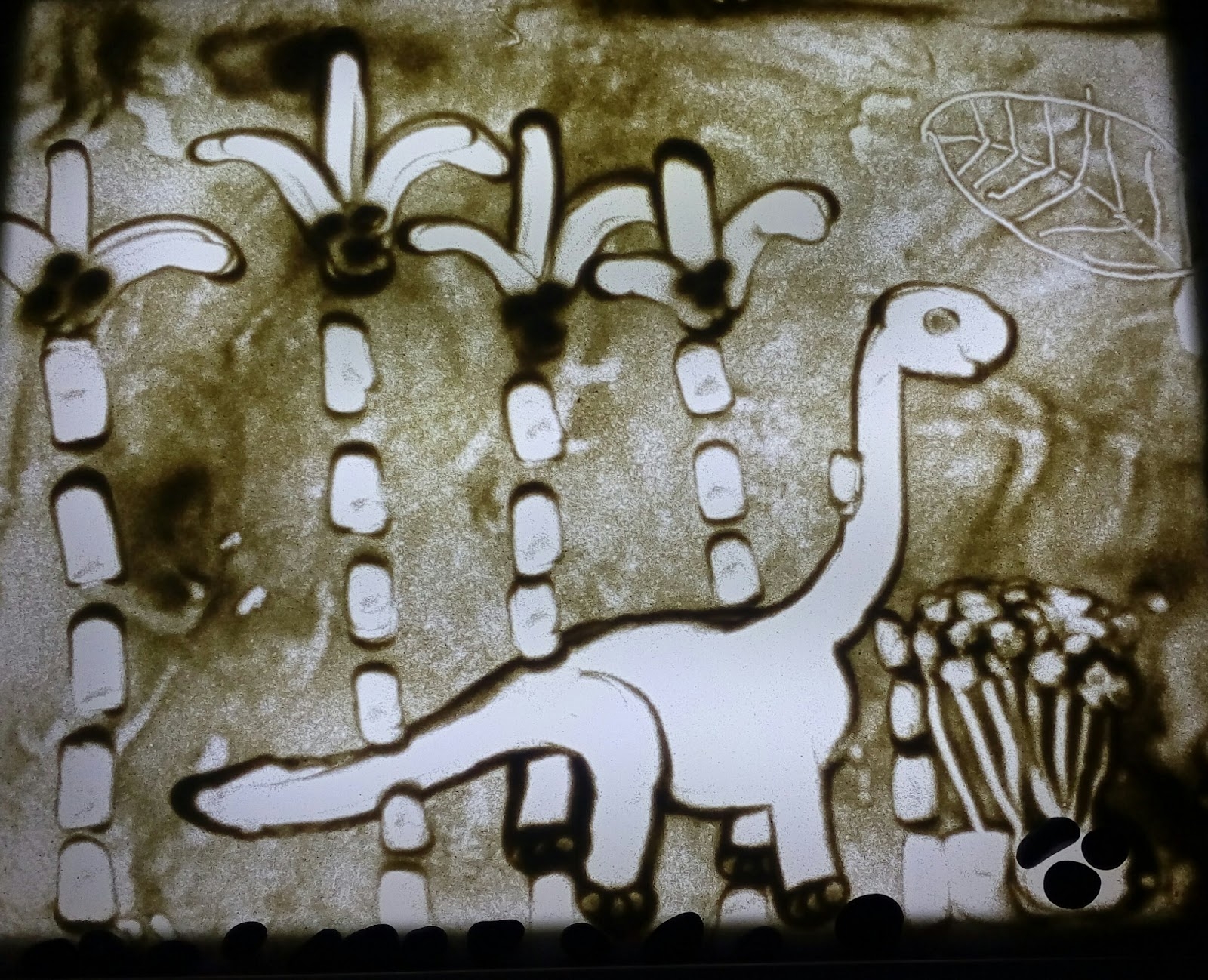 Рисование песком динозавров